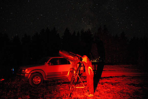 Chrissy looking through telescope with Milky Way overhead